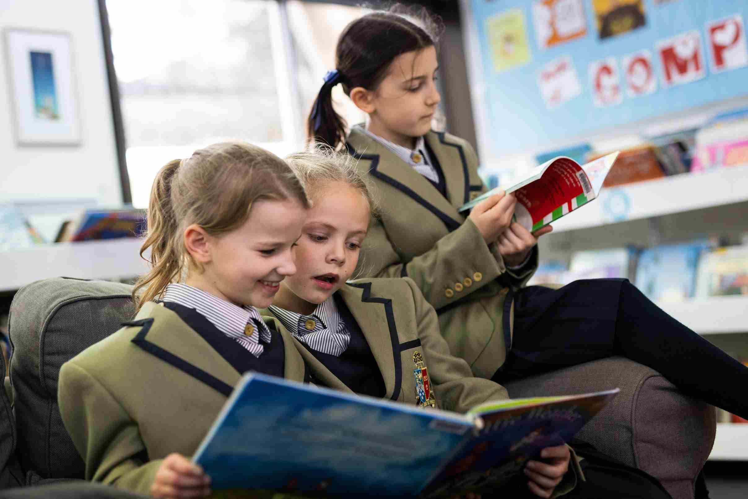 Three schoolgirls reading in the library