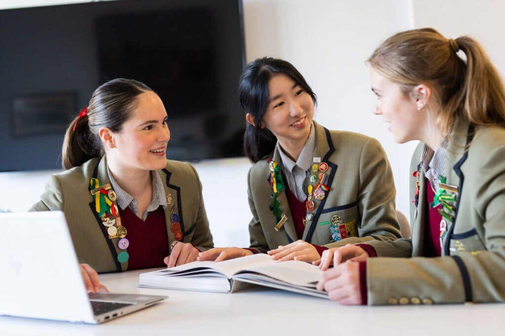 Three girl students chatting while smiling